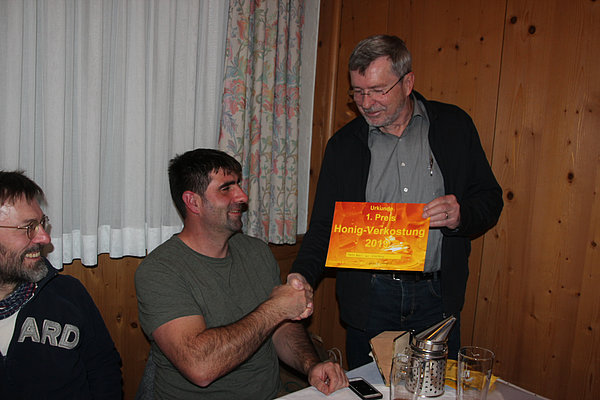 Siegerehrung  bei der Honigverkostung 2019. Der Vereinsvorstand Roland Gaugeleüberreicht Martin Wahl die Urkunde für den 1. Preis.